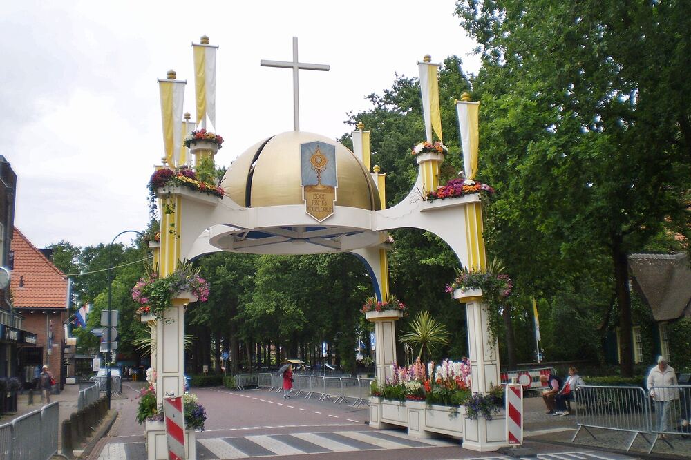 De versierde erepoort van de Larense Sint Jansprocessie over de straat
