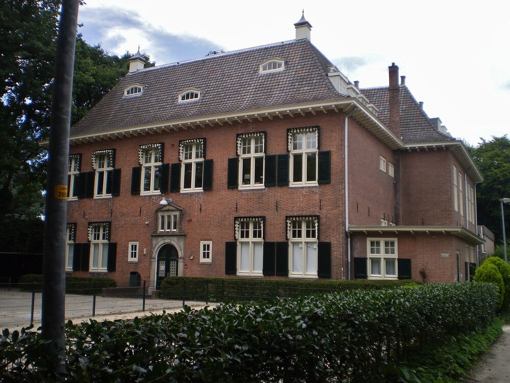 De Gooische School in Laren, een bakstenen schoolgebouw achter een haag